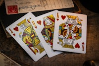 three playing cards on a wooden table