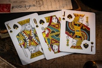 three playing cards on a wooden table